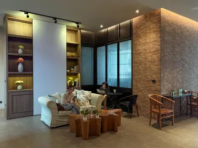 two people sitting on a couch in a living room at Silom Nara in Bangkok