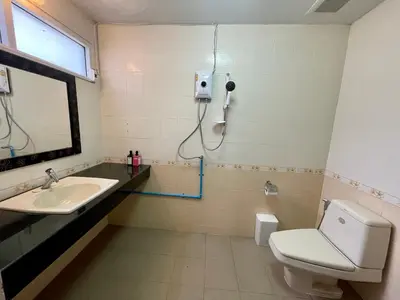 a bathroom with a sink and a toilet and a mirror at Doodle Lodge Bangkok in Bangkok