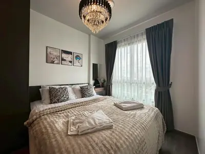 a bedroom with a bed with two towels on it at Monte Rama 9 near JodFair Market in Bangkok