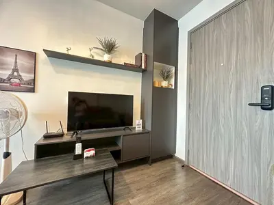 a living room with a flat screen tv and a table at Monte Rama 9 near JodFair Market in Bangkok