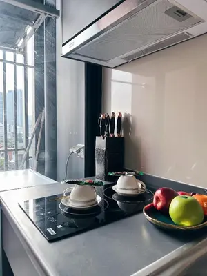 a kitchen with a counter with plates and fruits on it at Monte Rama 9 near JodFair Market in Bangkok