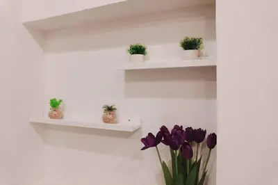 a room with white shelves with purple flowers and plants at BnB98 Silom Hotel in Bangkok