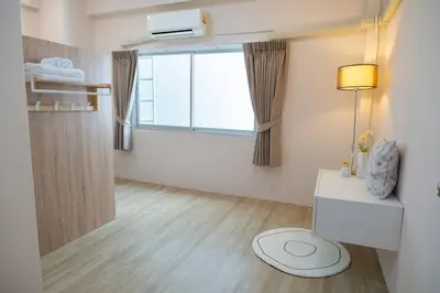 a room with a window and a table and a lamp at 2BR minimal mu-ji style 130SQM ~ in Makkasan