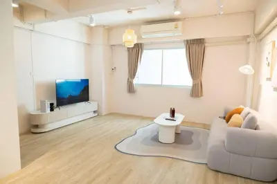 a living room with a couch and a tv at 2BR minimal mu-ji style 130SQM ~ in Makkasan