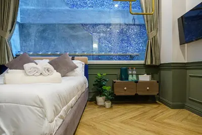 a bedroom with a bed and a large window at Ci home in Pom Prap