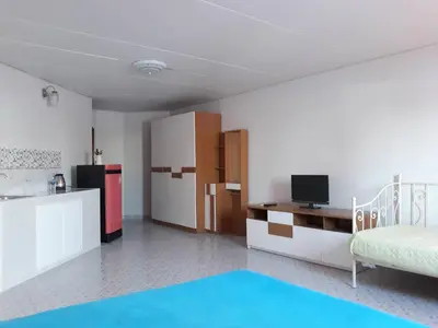 a living room with a bed and a kitchen with a refrigerator at T8impact Challenger Mueang Thon Thani Free WIFI in Nonthaburi
