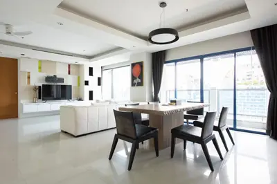 a living room with a table and chairs and a couch at M Estate 2BR Private Residence, 300m to BTS Chit Lom in Bangkok
