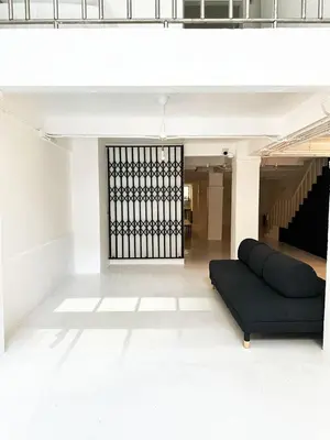 a living room with a black couch in a building at River Home Bangkok in Bangkok
