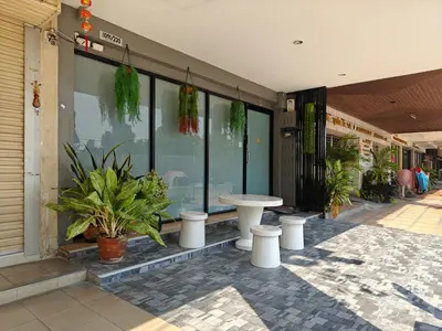 a store front with plants and a table on a sidewalk at Bangkok Watergate Townhouse \u66fc\u8c37\u4e2d\u5fc3\u6c34\u9580\u5bb6 in Bangkok