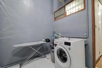a laundry room with a washing machine and a table at Bangkok Watergate Townhouse \u66fc\u8c37\u4e2d\u5fc3\u6c34\u9580\u5bb6 in Bangkok