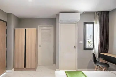 a bedroom with a bed and a cabinet and a window at iCheck inn Darisa Ngamwongwan in Nonthaburi