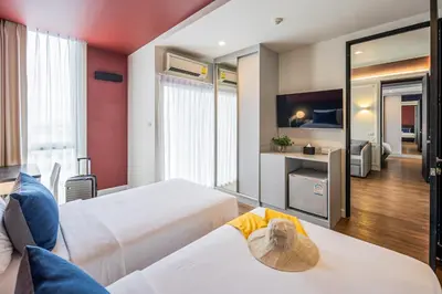 a hotel room with two beds and a mirror at Blue Hippo & Red Crocodile Hotel in Bangna