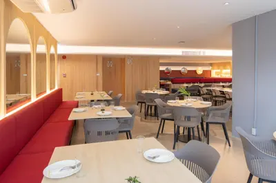 a dining room with tables and chairs and a restaurant at Blue Hippo & Red Crocodile Hotel in Bangna